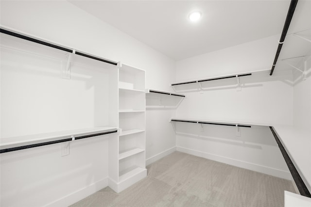 walk in closet featuring light colored carpet