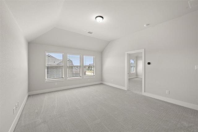 empty room with lofted ceiling and light carpet