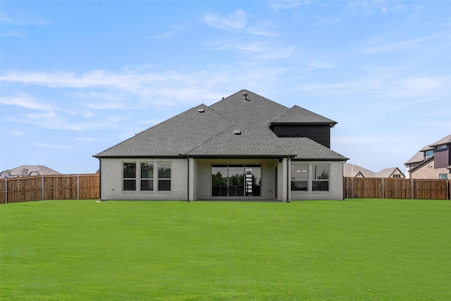 rear view of property featuring a lawn