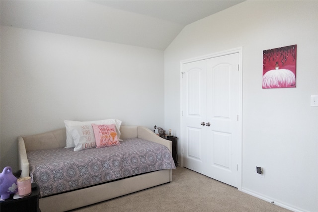 bedroom featuring light carpet and vaulted ceiling