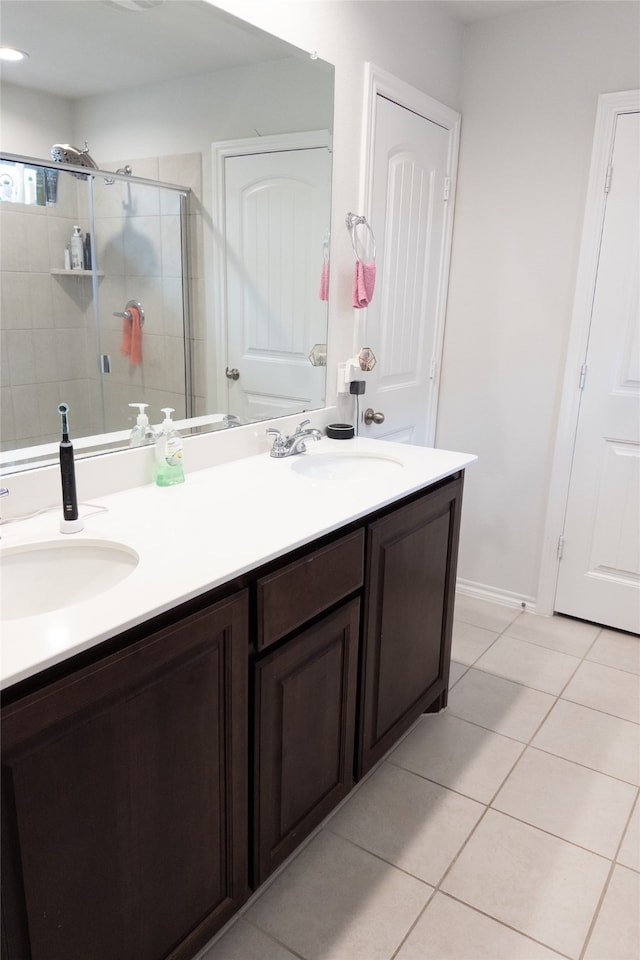 bathroom featuring tile patterned floors, a shower with shower door, and vanity