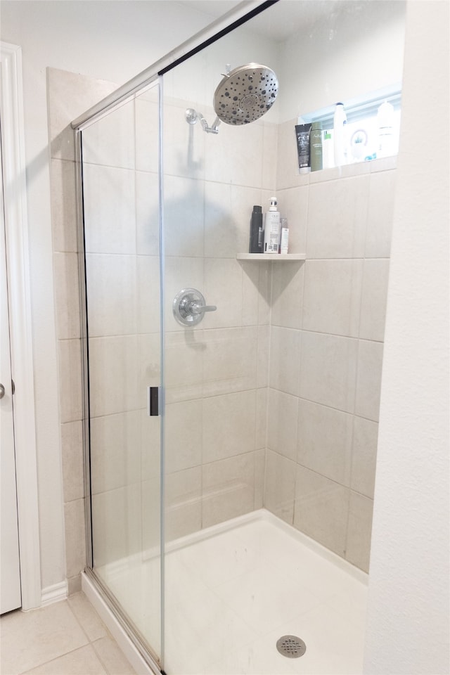 bathroom featuring a shower with door and tile patterned flooring