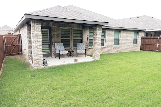 rear view of property featuring a patio area and a lawn