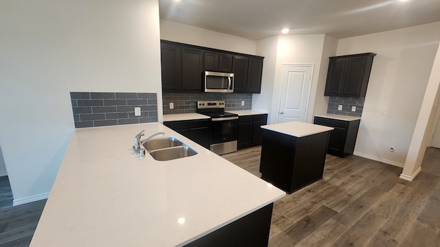 kitchen with sink, wood-type flooring, tasteful backsplash, and stainless steel appliances