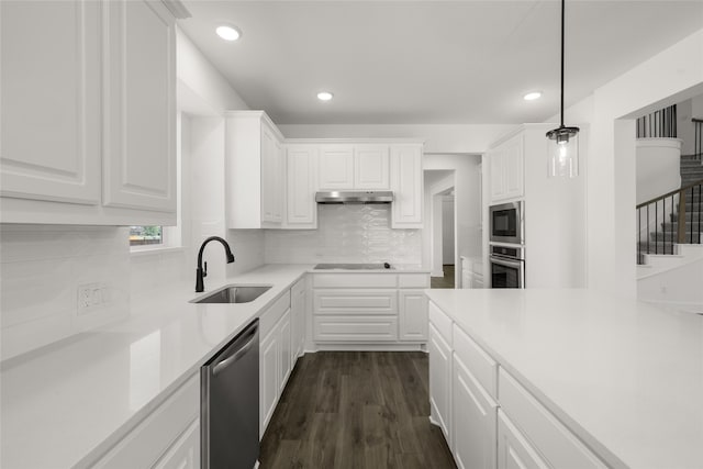 kitchen featuring dark hardwood / wood-style flooring, pendant lighting, appliances with stainless steel finishes, sink, and white cabinetry