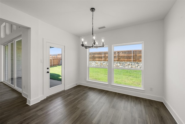 unfurnished dining area with dark wood-type flooring and a chandelier