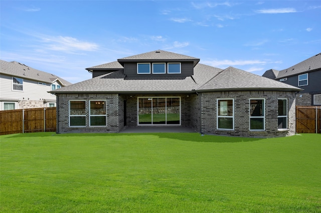 rear view of property featuring a lawn and a patio