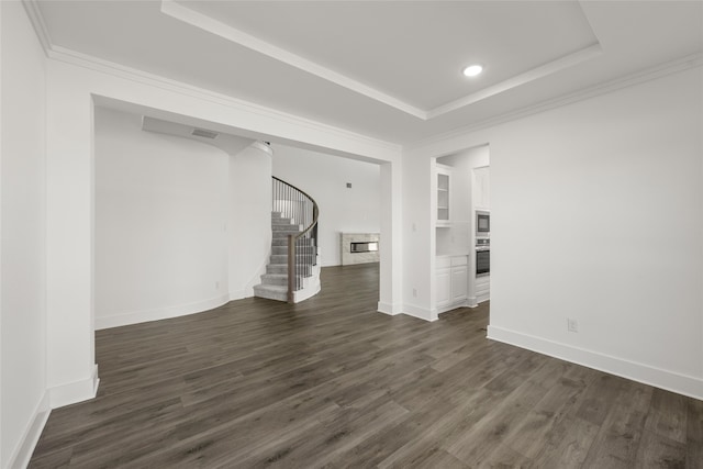 unfurnished living room featuring a tray ceiling and dark wood-type flooring