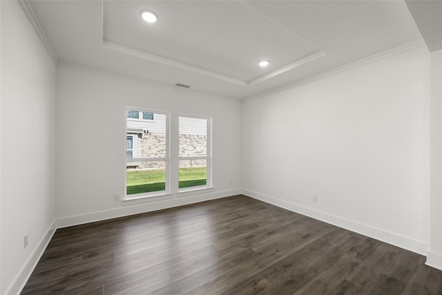 unfurnished room featuring a raised ceiling, ornamental molding, and dark hardwood / wood-style flooring