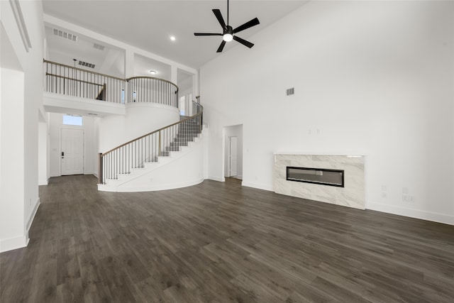 unfurnished living room featuring high vaulted ceiling, a fireplace, dark hardwood / wood-style floors, and ceiling fan