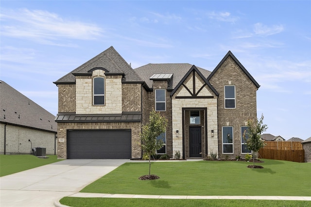 view of front of property featuring a front yard, a garage, and central AC