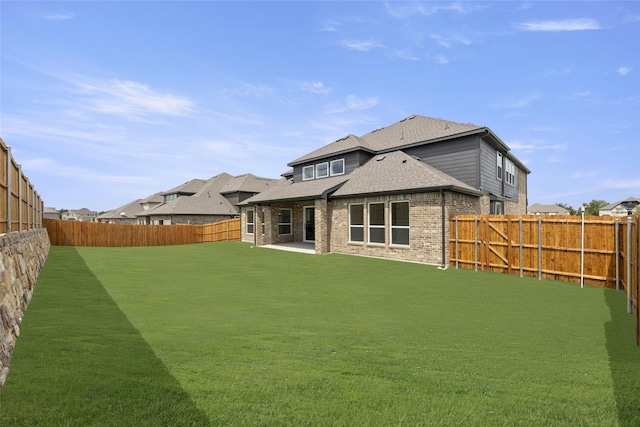 rear view of house with a lawn and a patio area