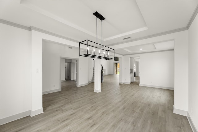 unfurnished dining area featuring light hardwood / wood-style flooring, crown molding, and a raised ceiling