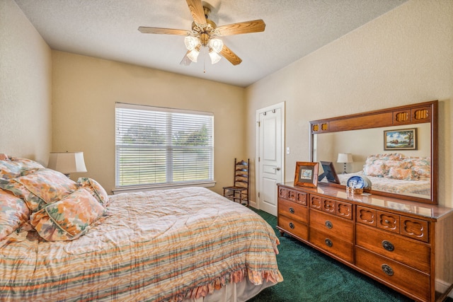 carpeted bedroom featuring ceiling fan and a textured ceiling