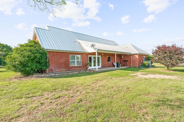 rear view of property with a yard