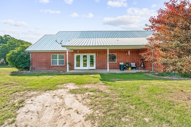 back of property with french doors, a lawn, and a patio