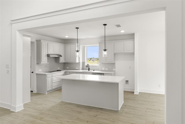 kitchen with a kitchen island, tasteful backsplash, light hardwood / wood-style floors, hanging light fixtures, and white cabinetry