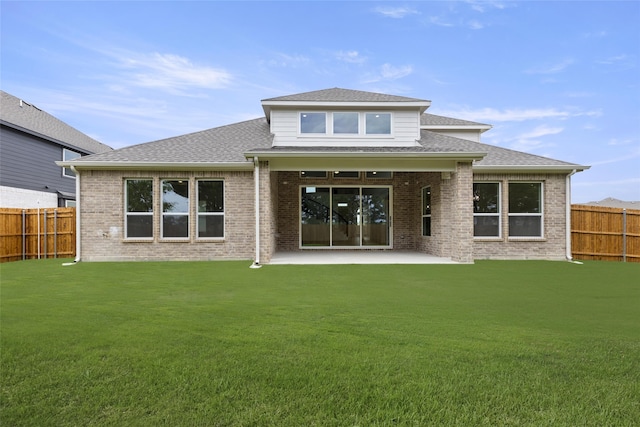 back of house featuring a lawn and a patio