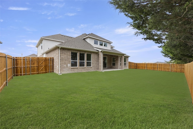 rear view of house with a yard and a patio area