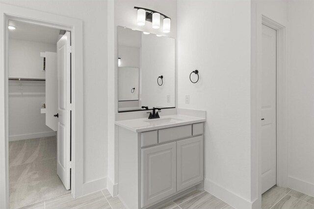 1710 Seagrove Ln, Cedar Hill, TX 75104 - bathroom featuring vanity, baseboards, and a walk in closet