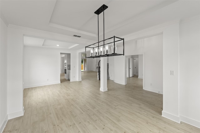 interior space with a tray ceiling, ornamental molding, and light hardwood / wood-style floors