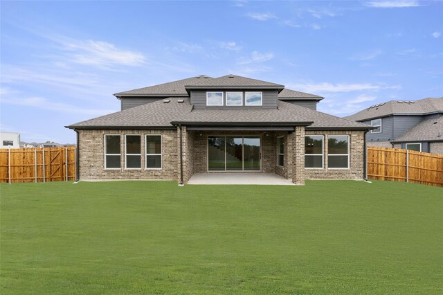 rear view of property featuring a patio area and a lawn