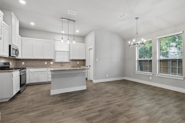 kitchen featuring appliances with stainless steel finishes, decorative light fixtures, dark hardwood / wood-style flooring, white cabinets, and a center island