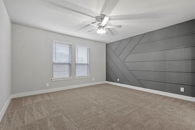 carpeted spare room with ceiling fan