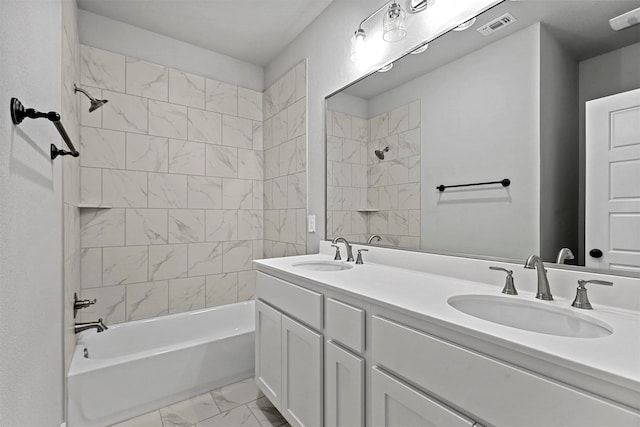 bathroom featuring tiled shower / bath and vanity