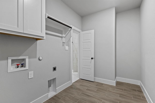 laundry area featuring light hardwood / wood-style floors, electric dryer hookup, cabinets, hookup for a gas dryer, and washer hookup