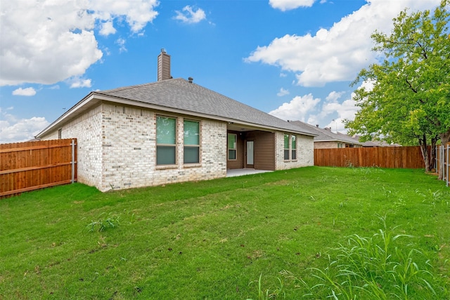 rear view of house featuring a lawn and a patio area