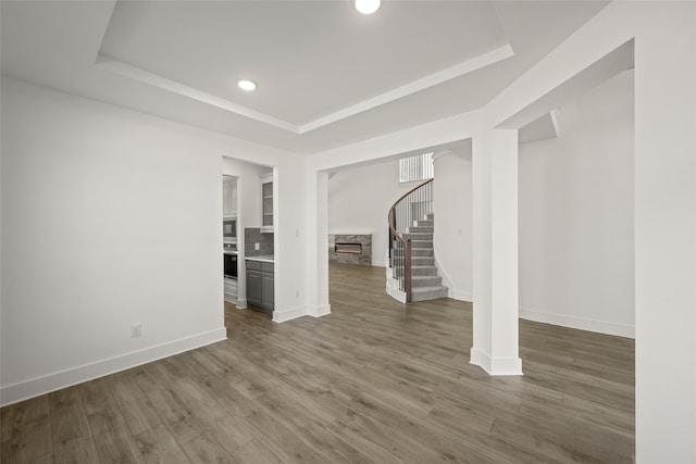 unfurnished living room with dark hardwood / wood-style floors and a raised ceiling