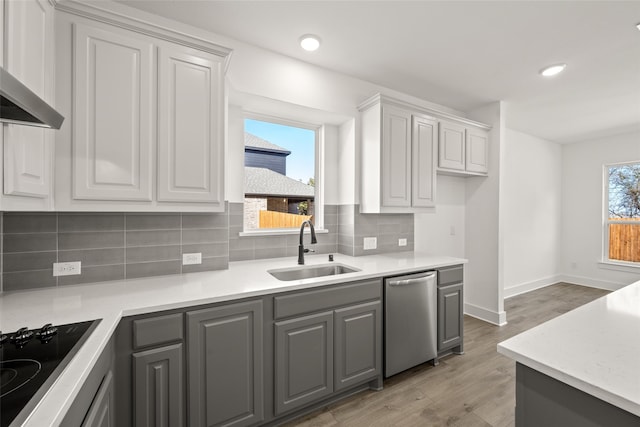 kitchen with gray cabinets, sink, light wood-type flooring, stainless steel dishwasher, and black electric cooktop