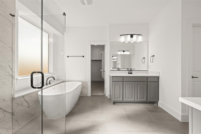 bathroom with tile patterned flooring, vanity, and a tub