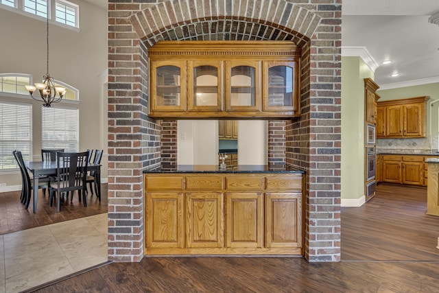 kitchen with a healthy amount of sunlight, an inviting chandelier, and hardwood / wood-style floors