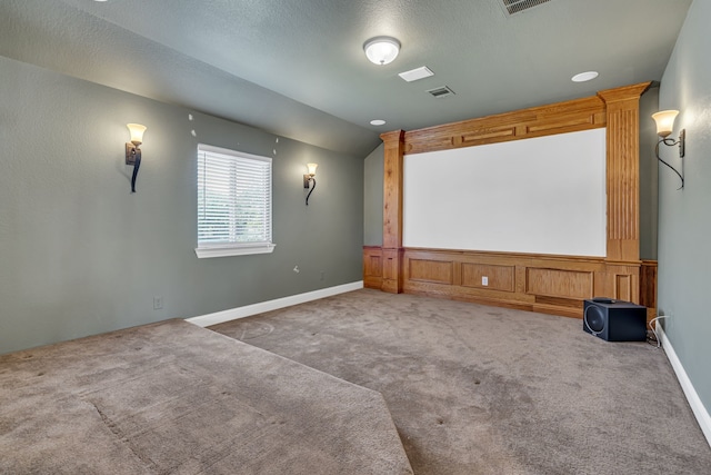 carpeted home theater room with a textured ceiling