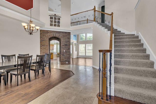 dining room featuring a chandelier, wood-type flooring, and a towering ceiling