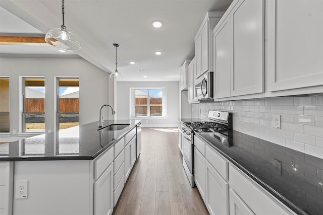 kitchen with recessed lighting, dark wood-style flooring, a sink, appliances with stainless steel finishes, and backsplash