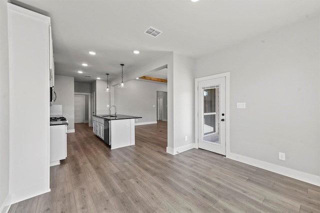 kitchen featuring visible vents, dark countertops, appliances with stainless steel finishes, wood finished floors, and white cabinetry