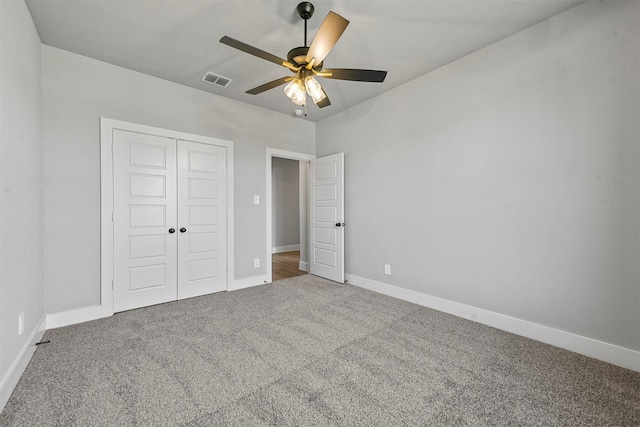 unfurnished bedroom with a closet, visible vents, a ceiling fan, carpet flooring, and baseboards