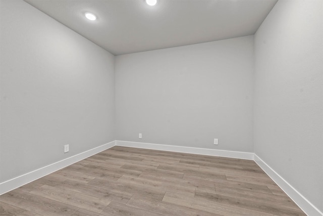 empty room with baseboards, recessed lighting, and light wood-style floors