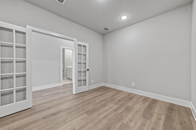 unfurnished room featuring baseboards, visible vents, wood finished floors, french doors, and recessed lighting