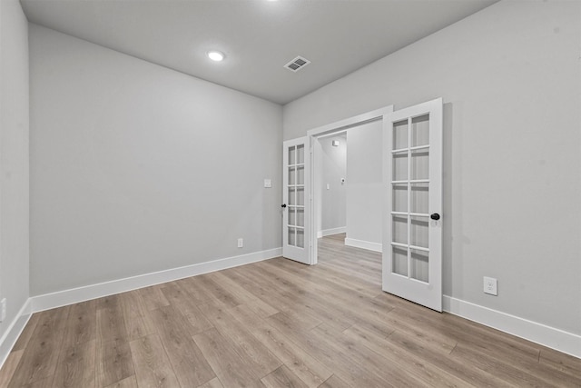 unfurnished room featuring french doors, visible vents, light wood-style flooring, and baseboards