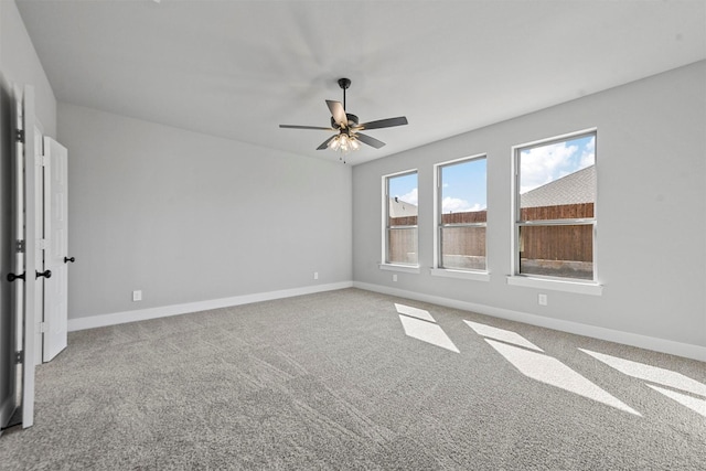 unfurnished room featuring carpet, baseboards, and a ceiling fan