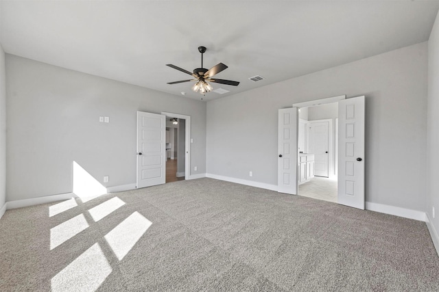 spare room featuring visible vents, light carpet, and baseboards