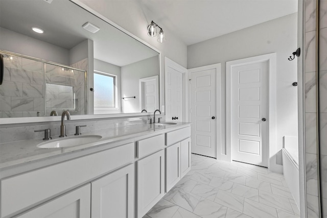 bathroom with double vanity, marble finish floor, a sink, and a stall shower