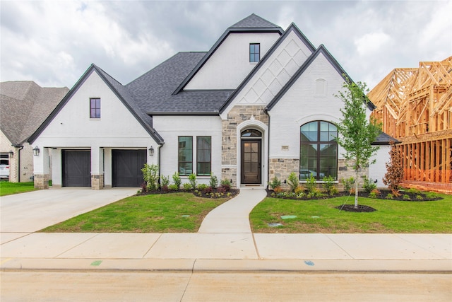 french country home with a garage and a front lawn