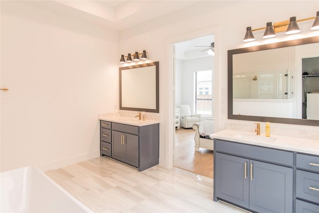 bathroom with dual bowl vanity, ceiling fan, hardwood / wood-style floors, and a shower with shower door