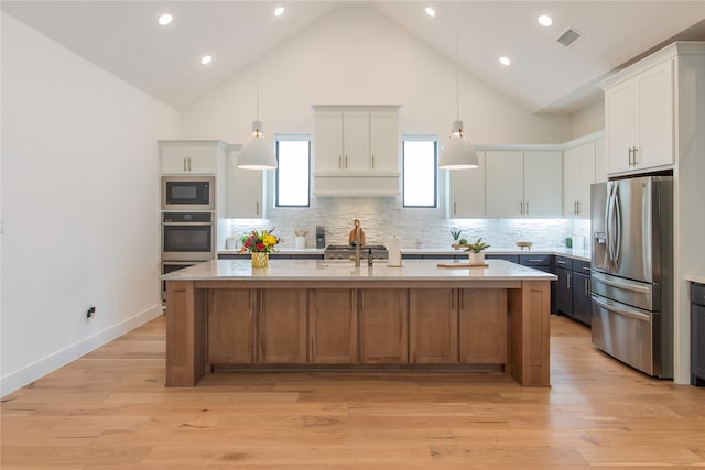 kitchen with stainless steel appliances, white cabinetry, and tasteful backsplash