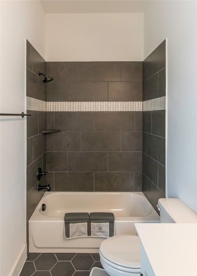 full bathroom with tile flooring, tiled shower / bath, vanity, and toilet